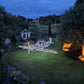 Garden with a large illuminated airplane sculpture at night.